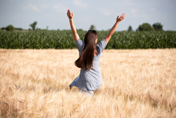 Portrait of happy girl in wheat field, nature of Ukraine. Growing grains for agricultural aims.Summer time 