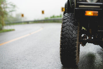 Off-road vehicles parked on wet paved roads. close up tire