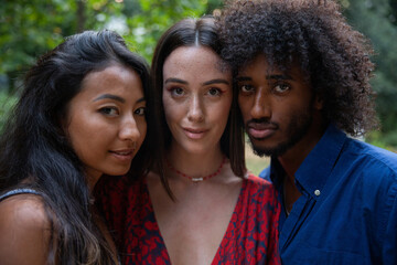 portrait of 3 young adults together of different ethnicities, cheek to cheek, concept of diversity...