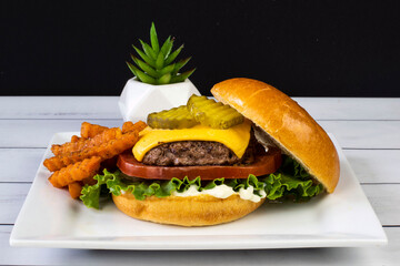 cheese burger top with pickles with sweet potato fries