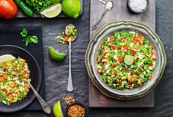 Arabic cuisine; Traditional middle eastern salad.Tabbouleh salad with fresh tomato,cucumber, parsley, mint, onion and bulgur. Top view with close-up.