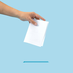 Creative concept of inserting the ballot into the box. It is your right to vote, exercise your right. Blue background..