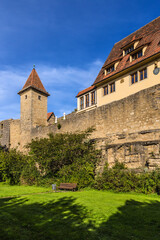 Fototapeta na wymiar Rothenburg ob der Tauber, Germany. Bench in the park under the medieval fortress wall