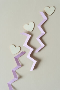 wood hearts with shreds of cut pink card stock on beige white paper