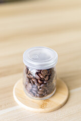 coffee beans in glass battle with wooden background