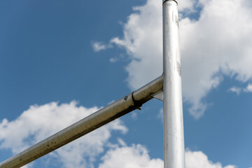 close up of an H football goal post (on a blue sky with clouds)
