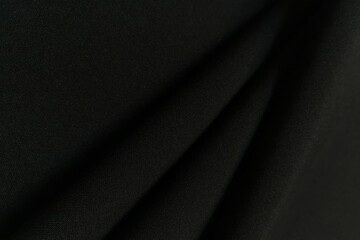 Black crumpled or wavy fabric texture background. Abstract linen cloth soft waves. Gabardine wool...