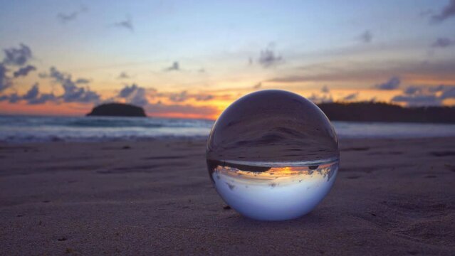 .view of beach sky at sunset inside crystal ball on a glass..sunset over sea in a crystal ball place on the beach video 4K. .Nature video High quality footage in nature and travel concept.