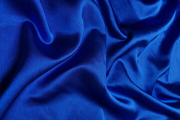 Blue crepe satin crumpled or wavy fabric texture background. Abstract linen cloth soft waves. Silk fabric. Smooth elegant luxury cloth texture. Concept for banner or advertisement.