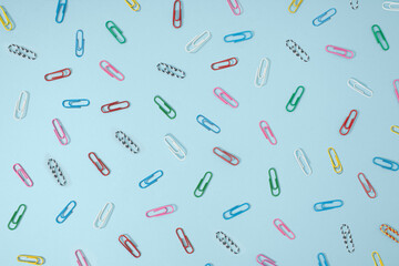 Creative office concept of .multi-colored paper clips on pastel blue background..