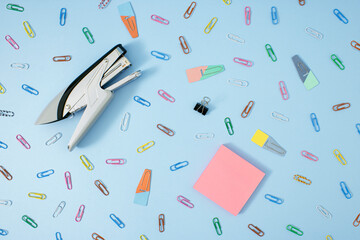 Creative office concept of .multi-colored paper clips on pastel blue background.