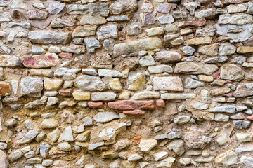 Wand oder Mauer aus Naturstein Ziegeln mit tiefen Fugen
