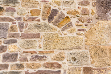 Wand oder Mauer aus bunten geometrisch angeordneten Sandstein Ziegeln mit gemauertem Bogen