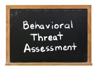 Behavioral threat assessment written in white chalk on a black chalkboard isolated on white - obrazy, fototapety, plakaty