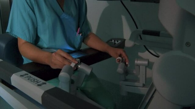 DOCTOR HANDS OPERATING THROUGH A PRECISION SURGERY MACHINE