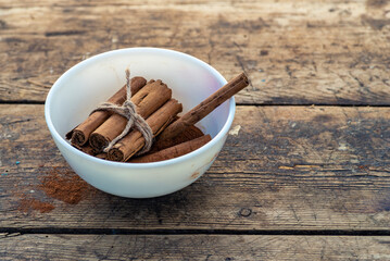 Organic Raw Brown  cinnamon sticks on old wooden table  wood stump trunk outdoor