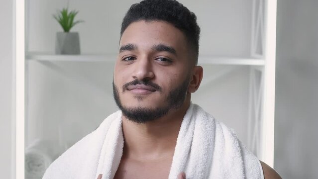 Morning grooming. Facial skincare. Freshness hygiene. Confident satisfied handsome guy face with stubble beard white towel on shoulders.