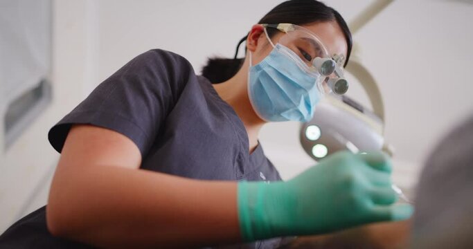 Dentist using excavator and mouth mirror tools on patient in hygienist clinic. Professional orthodontist or nurse using equipment to examine or check dental hygiene routine, fillings and gum disease