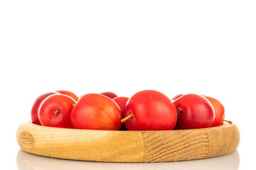 Several ripe juicy cherry plums on a wooden tray, close-up, isolated on a white background.