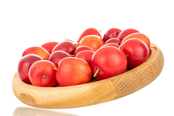 Several ripe juicy cherry plums on a wooden tray, close-up, isolated on a white background.