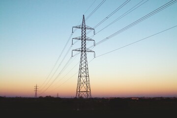 Silueta de torres de alta tensión para la conducción de electricidad. Imagen tomada al atardecer...