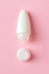 Roll on antiperspirant as the exclamation point shape on a pink background. Roll-on body deodorant in a white plastic tube. Hygiene and toiletries for reduce perspiration concept.