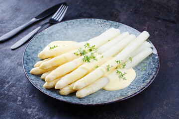 Modern style traditional steamed white asparagus with butter sauce hollandaise and cress served as...