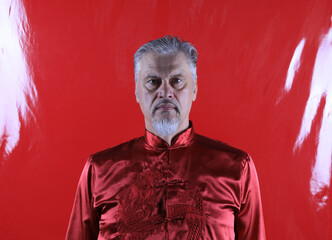 portrait of an old man in a red silk Chinese shirt