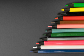 colored pencils with dark wood on a dark background