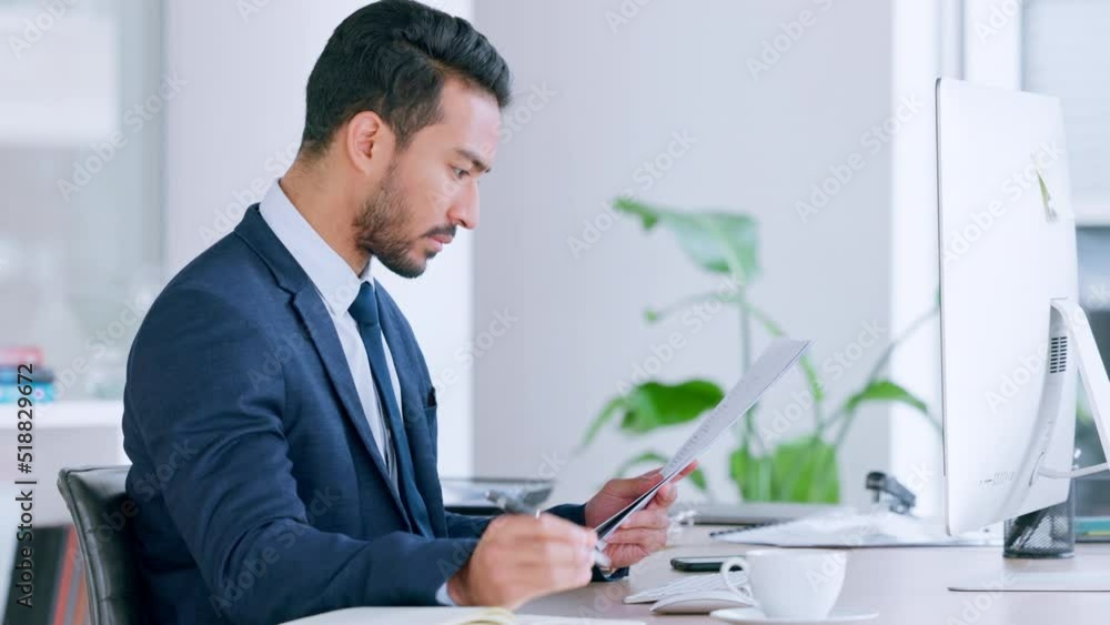 Poster Financial advisor reading a checklist and taking notes in a diary while working in an office alone. One serious male Asian finance manager organizing papers and documents for a client at work