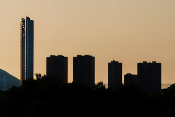 Fototapeta na wymiar Silhouettes at sunrise of large buildings next to a huge skyscraper, Benidorm.