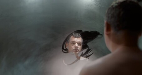 Frustrated man looking in steamy mirror - Powered by Adobe