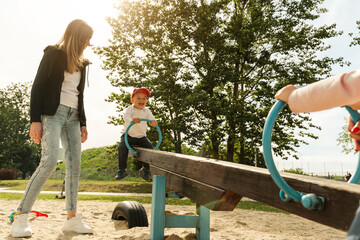 Mother and son having fun on seesaw. Motherhood and childhood concept. Sunny summer day