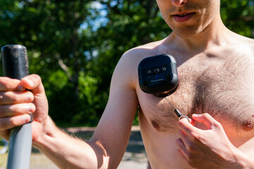 Intelligent, smart muscle tension reliever gadget, air cup cupping massager on a naked muscled male body