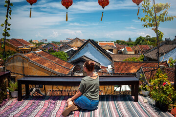 Mujer turista disfrutando de la ciudad de Hoi An desde una terraza