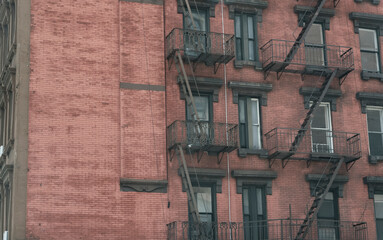Brown bricks of brownstone apartments with staircases in Manhattan New York