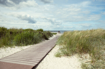 Fototapeta premium Pathway at white beach with green dune grass at Baltic sea in north Germany