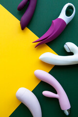 Collection of different types of sex toys on a green and yellow background.  - 518838456