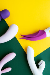 Collection of different types of sex toys on a green and yellow background.  - 518838469