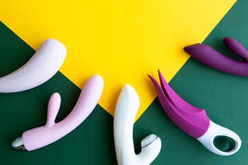 Collection of different types of sex toys on a green and yellow background.  - 518838498