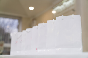 Fototapeta na wymiar Gift white packets standing. Light paper shopping bags.