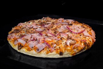Baked pizza with onion, mushroom, cheese, sauce on tray in electric oven. Italian cuisine, homemade bakery, fast food, cooking concept