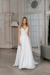 The beautiful woman posing in a wedding dress. Young beautiful happy bride wearing white wedding...