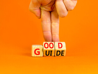 Good guide symbol. Concept words Good guide on wooden cubes. Businessman hand. Beautiful orange table orange background. Good guide and business concept. Copy space.
