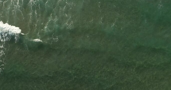 Aerial video of waves crashing on the rocks. 
