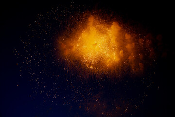 Bright orange glowing fireworks with sparks flying sideways against the night sky. High quality...