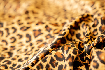 Satin fabric close up background and texture with place for text. Leopard print, silk orange.