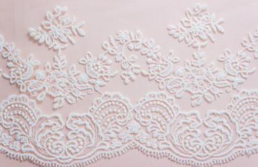 White lace on pastel background. Element of the bride's dress or veil. The concept of wedding invitation