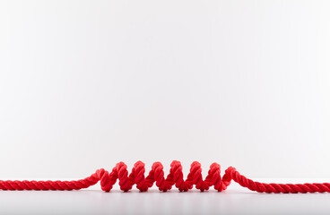 Red rope with a spiral Isolated on white background. - obrazy, fototapety, plakaty