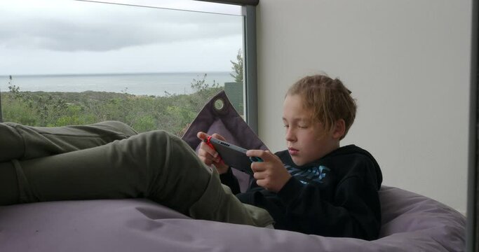 Teenager Boy Playing On Handheld Game Console